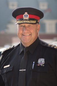 Headshot of former Chief of Regina Police Service, Evan Bray, in uniform, smiling.
