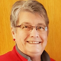 Thumbnail headshot of Linda Anderson. Smiling older graying woman wearing red.